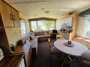 a living room with a couch and a table at 22 seabreeze holiday park in Hemsby