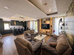 a living room with a couch and a table at Villa Dobric Apartments in Kavač
