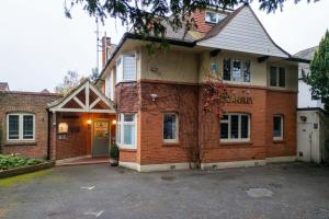 a brick house with a driveway in front of it at Cransley in Bournemouth