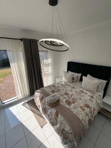 a bedroom with a bed and a large window at Randhart guesthouse in Alberton +67 photos