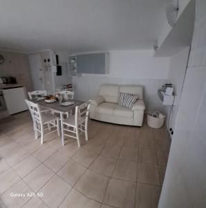 a living room with a table and a couch at Appartamento Catini 67 in Civitavecchia +5 photos
