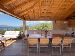 a dining room with a table and chairs on a deck at Villa Dobric Apartments in Kavač