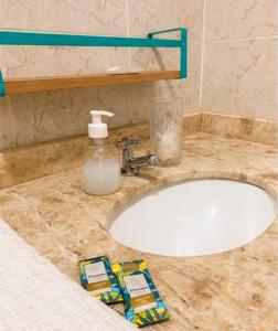 a bathroom sink with a bottle of soap on it at Pousada Estrela da Luz Refúgio in Muriú