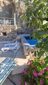 a blue bench and a swimming pool with flowers at Fannoun Getaway Lodge by Hansa in Ḩayy al Qal‘ah