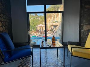 a living room with a glass table and a window at Fannoun Getaway Lodge by Hansa in Ḩayy al Qal‘ah