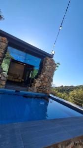 a house with a swimming pool with a stone wall at Fannoun Getaway Lodge by Hansa in Ḩayy al Qal‘ah