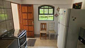 a kitchen with a refrigerator and a window at Recanto do majo in Petrópolis