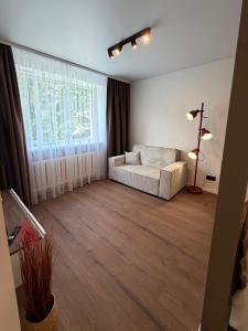 a living room with a couch and a large window at AC Central Station apartments in Daugavpils