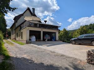 a car parked in front of a house with a car garage at Ferienwohnung am Hainer Berg in Heigenbrücken