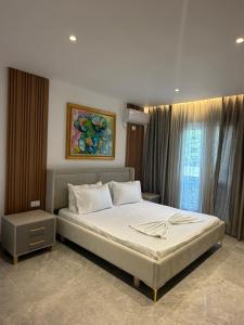 a bedroom with a bed and a painting on the wall at Durres Beach Rooms in Durrës