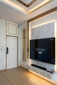 a living room with a large flat screen tv on a wall at Kanchanaburi Residence Hotel in Kanchanaburi City