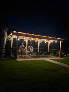 a gazebo with chairs and lights at night at Osada pod Sokolicą in Krościenko +56 photos