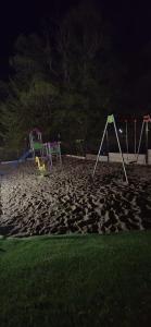a playground at night with playground equipment in the sand at Osada pod Sokolicą in Krościenko