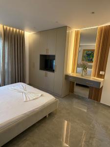 a bedroom with a bed and a flat screen tv at Durres Beach Rooms in Durrës