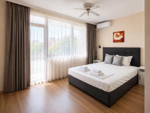 a bedroom with a large bed and a large window at Guestrooms Zoya in Chernomorets +30 photos
