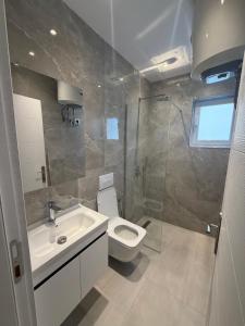 a bathroom with a toilet and a sink and a shower at Durres Beach Rooms in Durrës +24 photos