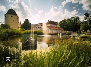a pond in front of a building with a water fountain at M&L Hartberg in Hartberg