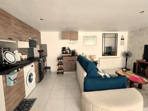 a living room with a blue couch and a kitchen at Celies Country Cottage in Blaru
