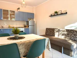 a kitchen and living room with a table and a couch at Lenka Apartments I in Novalja
