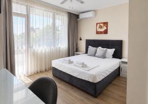 a bedroom with a bed and a large window at Guestrooms Zoya in Chernomorets