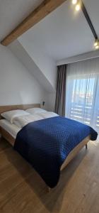 a large bed in a bedroom with a large window at Sarbinowo Lazur Spokojna in Sarbinowo