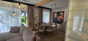 a living room with a couch and a table at Sarbinowo Lazur Spokojna in Sarbinowo