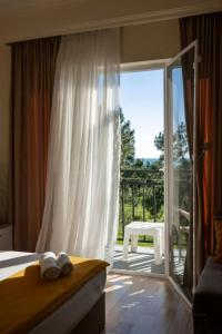 a bedroom with a bed and a sliding glass door at Iveria Elli Hotel in Shekhvetili +110 photos