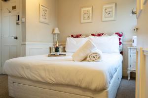 a bedroom with a large white bed with towels on it at Cransley in Bournemouth