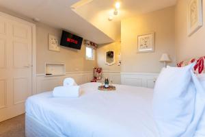 a bedroom with a white bed with a clock on the wall at Cransley in Bournemouth