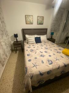 a bedroom with a bed and two tables with lamps at Cozy Beach Apartment in Luquillo