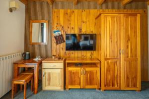 a room with wooden cabinets and a tv on a wall at Rooms and apartmants Mirovic in Kolašin