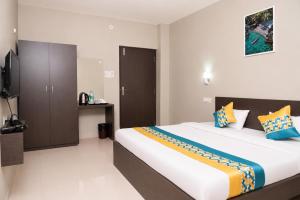 a bedroom with a large bed and a television at Hotel Vilasa Grand in Guwahati