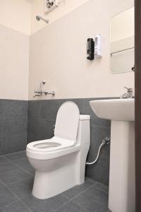 a bathroom with a toilet and a sink at Hotel Vilasa Grand in Guwahati