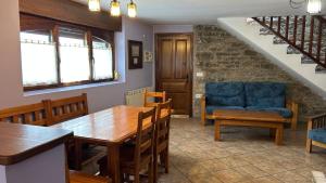 a dining room with a table and a blue couch at Casa Rural GABARDA in Aso de Sobremonte