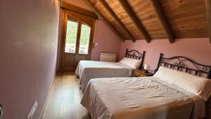 a bedroom with two beds and a window at Casa Rural GABARDA in Aso de Sobremonte