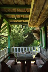 a porch with a table and chairs and a fence at Jurina Hiža in Beletinec