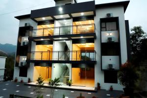 a tall building with a person standing on the balcony at Aamys Home in Kalpetta +11 photos