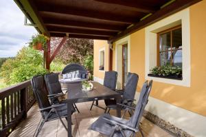 a patio with a table and chairs on a balcony at Ferienwohnung Nähe Dresden mit Pool & Spielplatz - FeWo "Waldblick" und "Gartenblick" an der Talsperre Malter in Dippoldiswalde