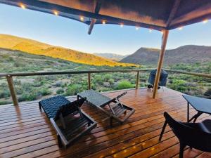 a deck with chairs and a view of the mountains at Oudemuur Glamping in Montagu +14 photos