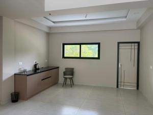 a kitchen with a counter and a chair in a room at Aamys Home in Kalpetta