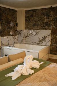 a room with a tub and a towel on the floor at Aprosmeno House 5 in Agros