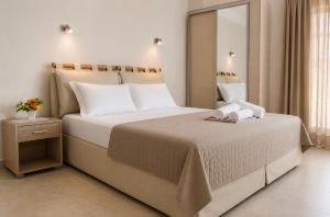a bedroom with a large bed with white pillows at Hotel Olivia in Agiokampos