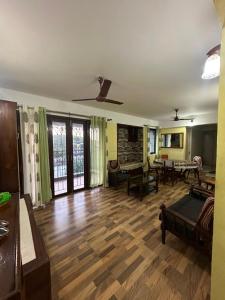 a living room with a hard wood floor and tables at ChriSeph in Kottayam