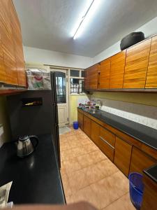 a kitchen with wooden cabinets and a black counter top at ChriSeph in Kottayam