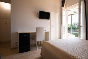 a bedroom with a bed and a desk with a chair at Country Resort Le Due Ruote in Alberese
