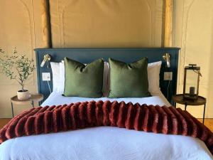 a large bed with a red blanket on it at Oudemuur Glamping in Montagu