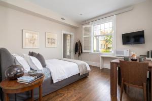 a bedroom with a bed and a desk and a television at Les Suites Du Vieux-Lévis - With AC and Parking in Lévis