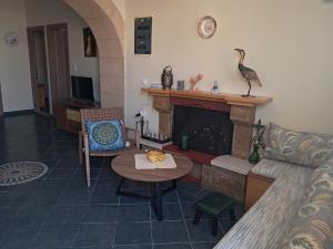 a living room with a table and a fireplace at Anthias Beach Home in Archangelos