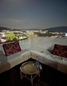 a room with two beds and a table with a water bottle at Dar fenan Lina in Chefchaouen