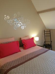 1 dormitorio con 1 cama grande con almohadas rojas en La Tannerie du Port, en Dinan